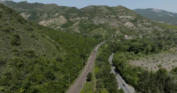 在佐治亚州的Mtskheta 货运列车将货物通过铁路运送到隧道通过山 空中后撤 — 图库视频影像