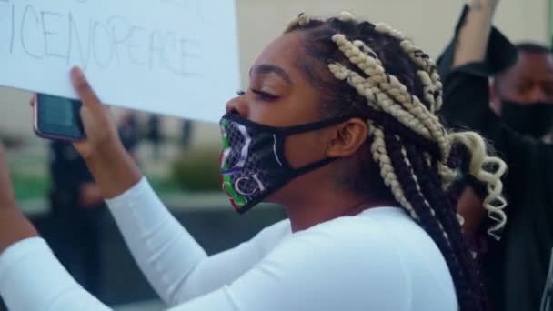 署を持つ黒人女性が警察署の外でBlm抗議で警察と対決する — ストック動画