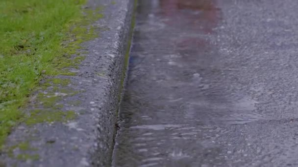 沥青路面上的一个特写镜头 在那里由于大雨而积水 夏天雨天的乡村道路全景 — 图库视频影像