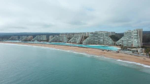 チリのアルガルロノにある世界最大のスイミングプールとリゾートの近くに海と砂のビーチの航空トラック — ストック動画