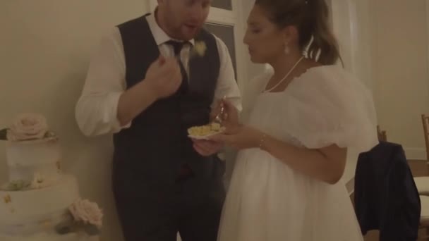 Joven Pareja Boda Comiendo Pastel Riendo Mientras Celebra Matrimonio Interior — Vídeo de stock