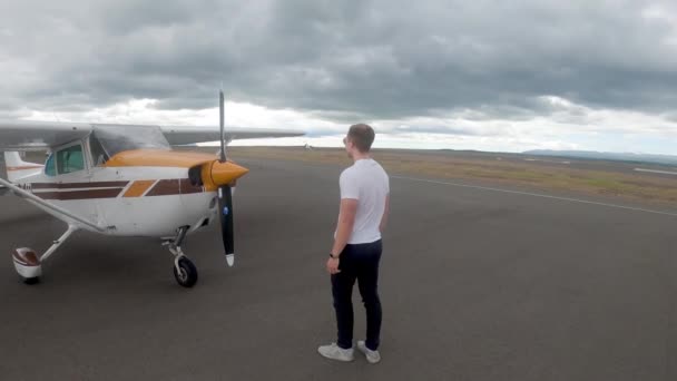 Pilot Stojí Před Zaparkovanou Cessnou 172 Skyhawk Plane Oblačném Dni — Stock video