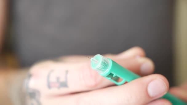 Zbliżyć Ujęcie Osoby Tatuażami Zdejmującej Zabezpieczenie Przed Igłą Przymocowaną Wstrzykiwacza — Wideo stockowe