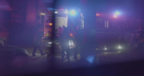夜に救急車の後ろに年配の女性が輪になっている — ストック動画