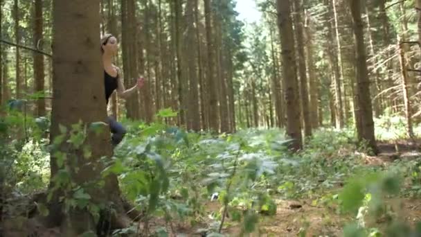 女性は長い踏み台と森の中を走り始める 心臓の健康とフィットネスの外 トレイルランニング 平和的な運動環境 スローモーション Pan権利 — ストック動画