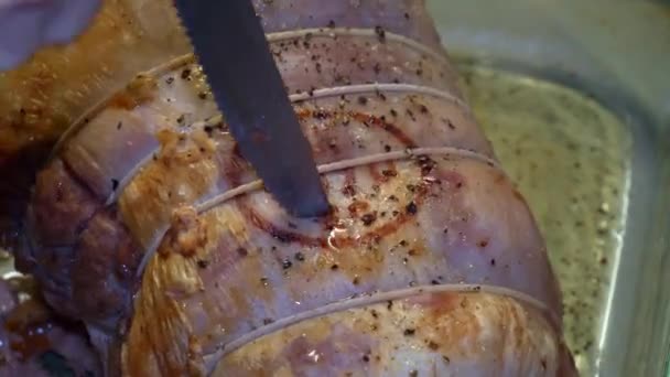 用肉刀在玻璃杯烤盘上切半块熟的猪肉 — 图库视频影像