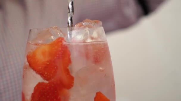 斯洛气象 Slowmo 男性酒吧招待在玻璃杯中用草莓和冰块装饰杜松子酒和滋补品饮料鸡尾酒 — 图库视频影像