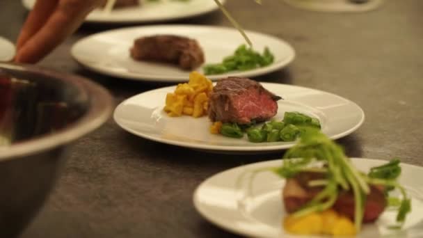 Slowmo Chef Bereitet Rindersteak Mit Gemüse Auf Weißem Teller Auf — Stockvideo