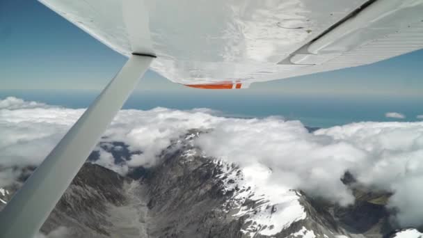 飞机在西海岸 弗朗茨 约瑟夫 奥拉基山 国家公园和云层 冰雪覆盖的岩石山和海洋上空盘旋拍摄的空中风景 — 图库视频影像