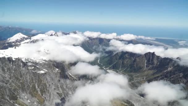 Slowmo 西海岸の飛行機の風光明媚な飛行からの空中ショットフランツ ヨゼフ氷河 アオラキ山クック 国立公園雲 雪に覆われた岩の山と海を背景に — ストック動画