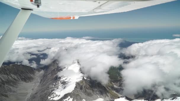 Slowmo 西海岸の飛行機の風光明媚な飛行からの空中ショットフランツ ヨゼフ アオラキ山クック 国立公園雲 雪に覆われた岩の山と海を背景に — ストック動画