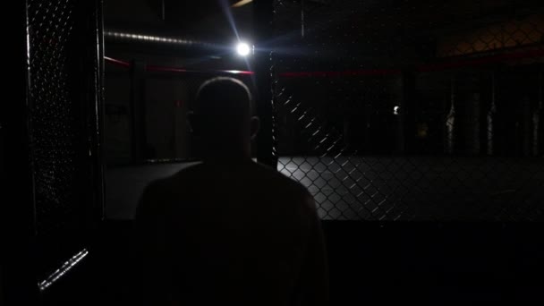 一个母亲战士进入拳击台 然后在黑暗的房间里准备一场横向的战斗 背景上只有一盏灯 动作缓慢 — 图库视频影像