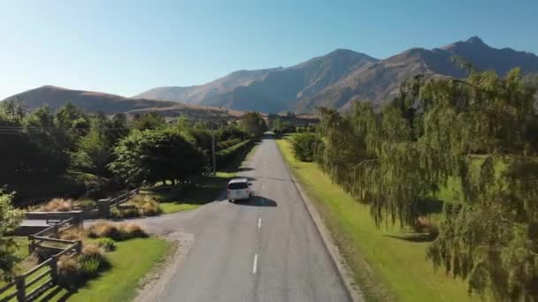 在新西兰Arrowtown和Questown附近的公路上行驶的豪华面包车 背景是群山丛生的 — 图库视频影像