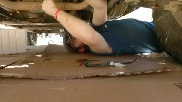 Estática Toma Hombre Encuentra Bajo Camión Haciendo Reparaciones Día Caluroso — Vídeo de stock