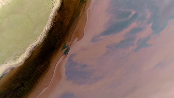 砂丘と草の側と赤い絹の色の砂州の間の対照的な暗い色の川の彫刻の上 — ストック動画