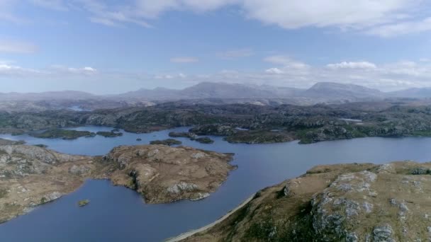 スコットランドの圧倒的な山岳地帯に複数の島がある広大な湖のサイドウェイ — ストック動画
