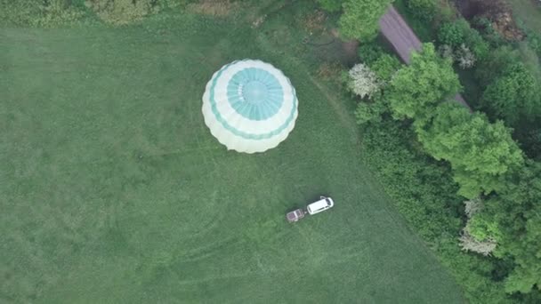 在绿地里启动热气球的高角镜头 旁边有车和拖车 — 图库视频影像