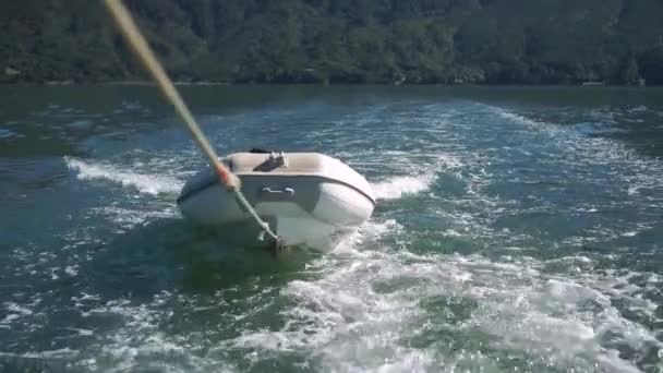 Slowmo Bote Inflable Remolcado Cuerda Detrás Del Barco Océano Nueva — Vídeos de Stock