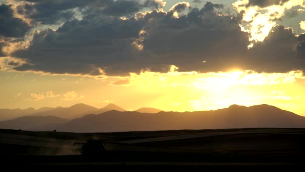 科罗拉多州农村的联合收割机 在高山和日落的背景下 — 图库视频影像