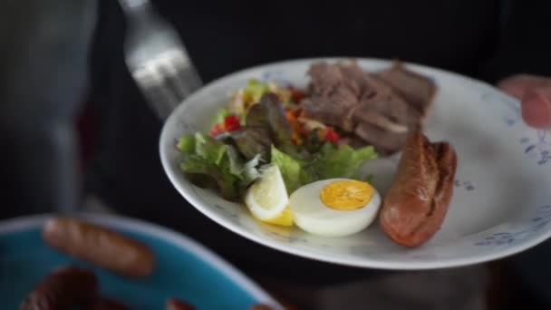 Adam Sağlıklı Tabağına Yumurta Salatayla Sosis Hamburger Koyar — Stok video