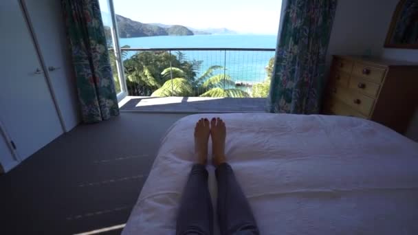 女孩躺在床上躺在豪华的休养所里 欣赏着新西兰的万宝路声音 — 图库视频影像