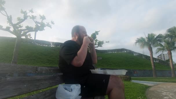 Obese Man Takes Big Bite Out Burger Alone Park Bench — Stock Video