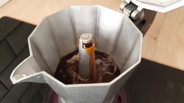 ゆっくりと開いたステンレス製のモカ鍋に小さな穴から注ぐコーヒー スローモーションでイタリアのブラックコーヒーを作る コーヒーを沸かす コーヒーの淹れ方 — ストック動画