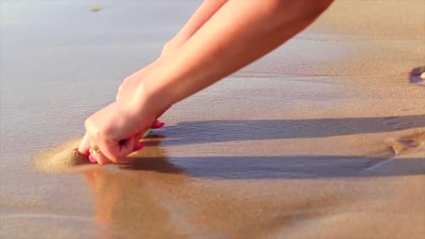 心のビーチの砂の中に女の子によって描かれている 愛の概念 ラブメッセージ — ストック動画