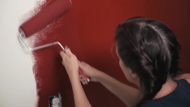 年轻的女人在家里画红墙 住房改善项目 — 图库视频影像
