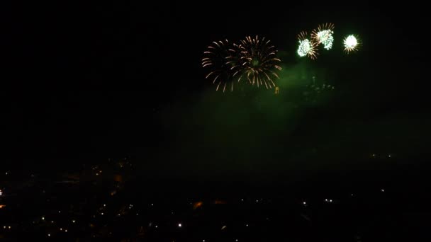 山の町の上で夜にカラフルで輝く花火でお祝い — ストック動画