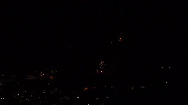 山の町の上で夜に多くの小さなカラフルな花火でお祝い — ストック動画