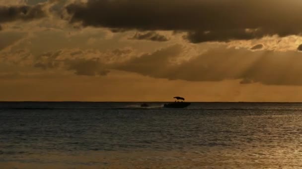 一艘拖曳着一个大浮子的运动船 船里有许多人在阳光下通过 阳光在云层中反射 — 图库视频影像