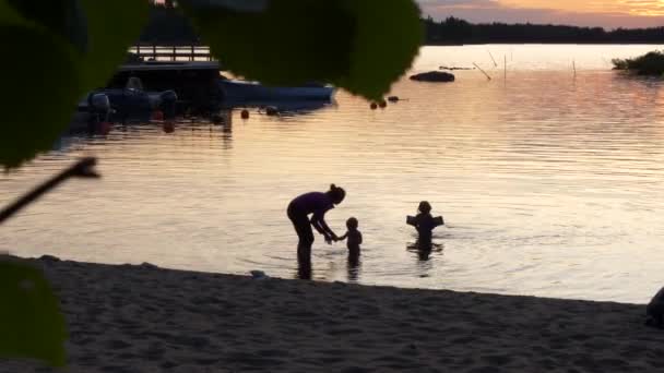 Силуети Хлопчика Мамою Сестрою Плавають Пляжі Під Час Заходу Сонця — стокове відео