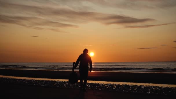 Mann Läuft Mit Gitarre Hinteren Sandstrand Bei Sonnenuntergang Schöne Stimmungsvolle — Stockvideo