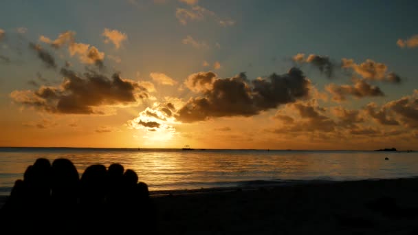 左前景に足のペアのシルエットと 楽園のビーチで夕日と静的な撮影 — ストック動画