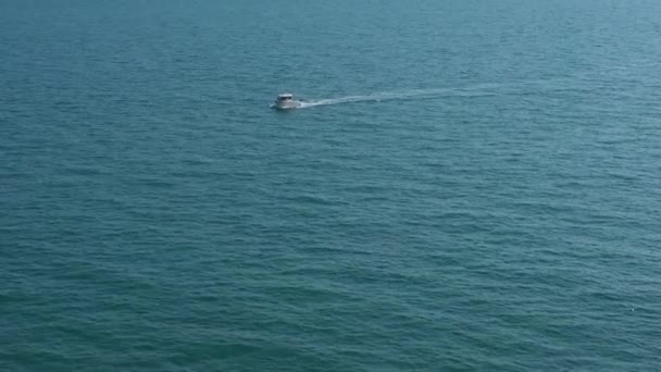イギリスのブライトン近くのイングリッシュ チャンネルで唯一のレジャー 釣りボート 負の空間をフレームを通過するボートの空中ビュー — ストック動画