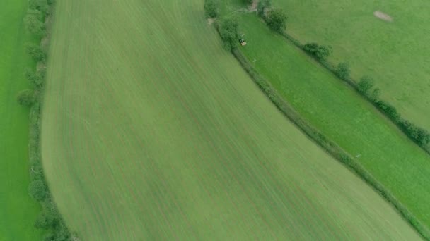 Luchttracking Langs Groene Engelse Velden Met Een Grotere Trekker Maaier — Stockvideo