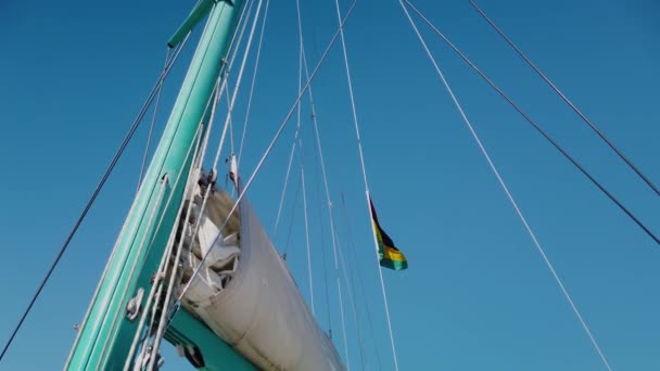 多くのストレート弦が立ち上がっているマストの下からのショット そして帆のあるブームの一部が滞在しました モーリシャスの旗にも見えます — ストック動画