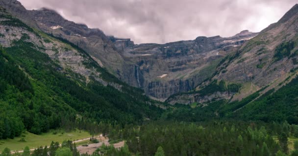 ガヴァーニー渓谷の日没の経過 前景としてガヴァーニーの小さな町と背景として大きな滝 山の峰で雲 フランスのピレネー山脈 — ストック動画