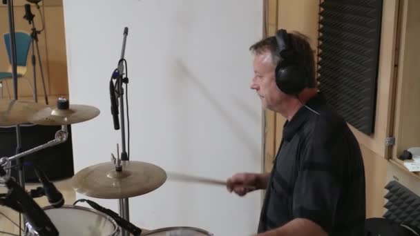 男は音楽スタジオでドラムを演奏 サイドビュー — ストック動画