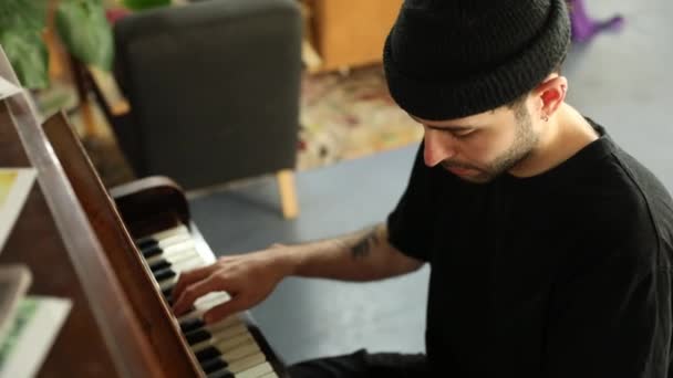 年轻男子坐在一架老式古典钢琴上弹奏曲调的侧貌图 — 图库视频影像