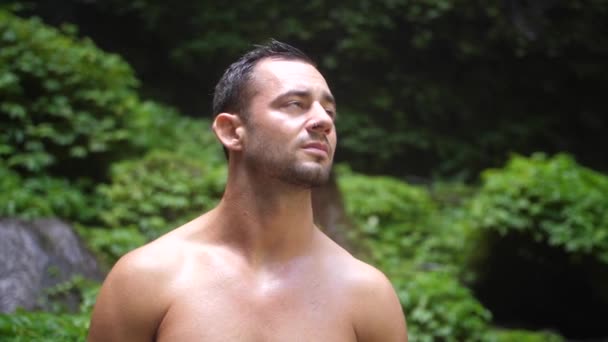 バリの緑豊かなジャングルの中でカメラと彼の周囲を見て 深刻な顔の表情を持つ若い 魅力的な男 — ストック動画
