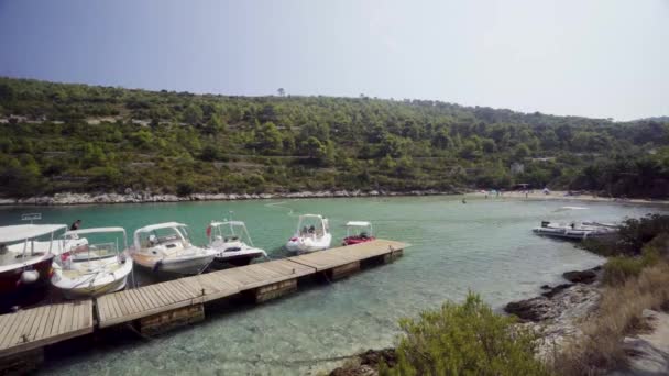 美丽的清澈温暖的水在一个偏僻的泻湖与小码头和船只停泊 克罗地亚岛屿的美丽 阳光温暖的岛屿度假天堂场景 — 图库视频影像