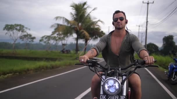 Młody Wysportowany Fajny Człowiek Jeździ Wiejskich Drogach Bali Swoim Motocyklem — Wideo stockowe