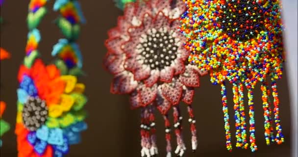 Huicholメキシコのアートワークのショットを閉じます ビーズのネックレスやブレスレットは 地元のアートフェアで展示されています すべての種類の職人は自分の工芸品を示す — ストック動画