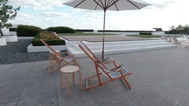 日当たりの良い日に風に優しく移動ビーチハウスの裏庭で空の椅子のリネンのスローモーション — ストック動画