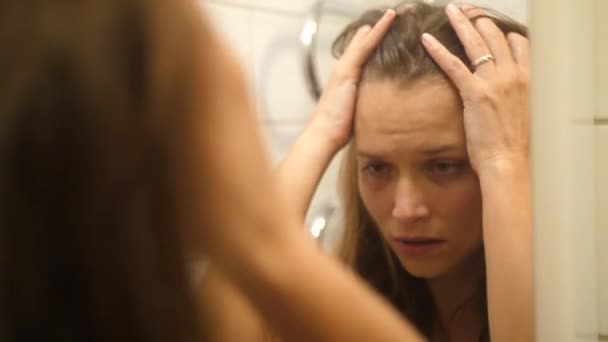 彼女の顔にあざや傷を持つ女性がパンチされ ヒットは 鏡の中で自分自身を見て パニックに彼女の頭と髪をつかむ 失われた感じと動揺 — ストック動画