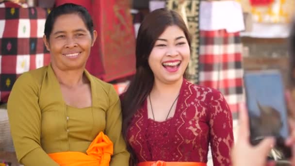 2人の女性が笑顔 携帯電話の写真のポーズ ソーシャルメディアの投稿コンセプト ヒンズー教の寺院の儀式の女性は友人が電話で撮影した写真を持っています — ストック動画