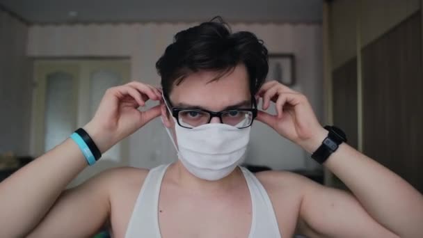 Ein Junger Mann Mit Brille Setzt Sich Eine Maske Auf — Stockvideo