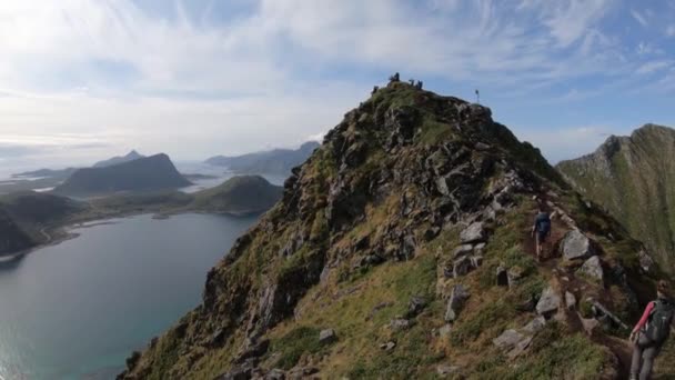 几个徒步旅行者正沿着小径走到曼宁山山顶 俯瞰着挪威罗浮敦的豪克兰海滩和峡湾 — 图库视频影像
